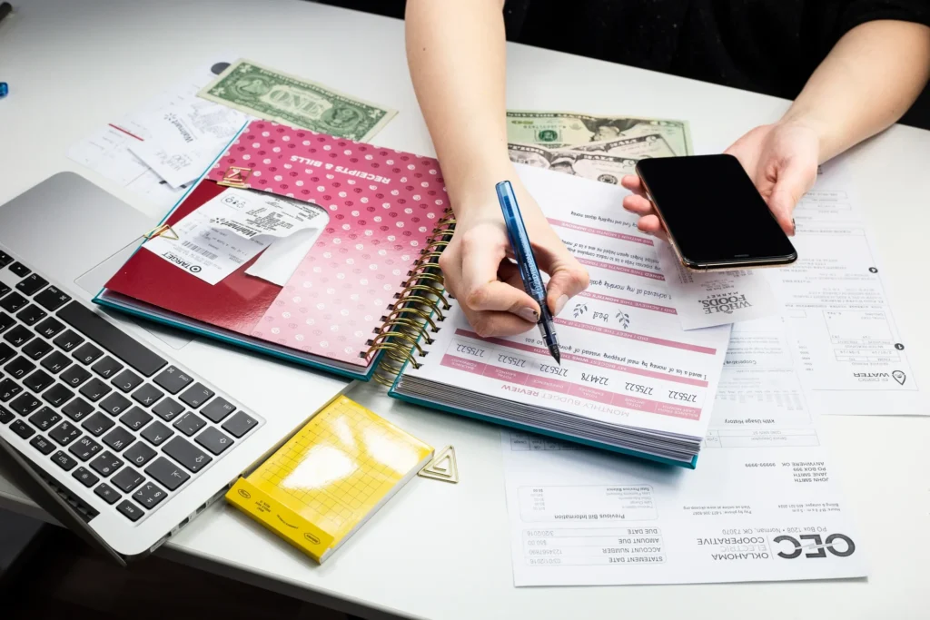 Person planning savings with emergency fund and expense categories on desk