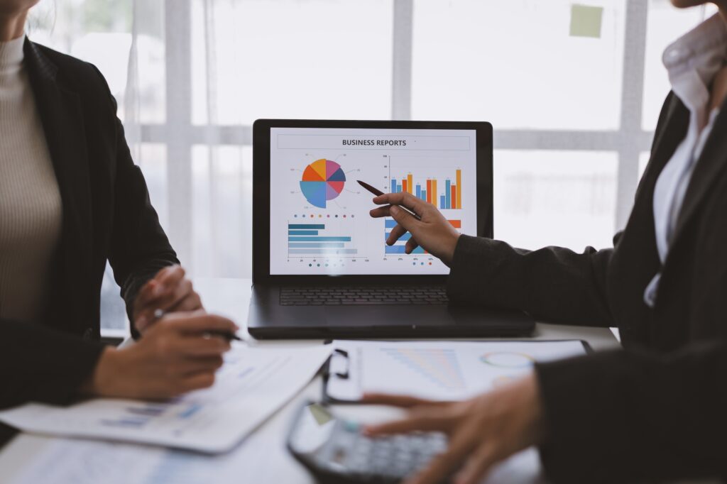 Person comparing short medium and long term financial plans with notes and laptop.